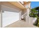 Welcoming entryway featuring a white garage door, white entry door and column at 1206 Gulf Blvd # C, Indian Rocks Beach, FL 33785