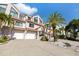 Inviting townhome boasts an attached garage and well-maintained landscaping with mature palm trees at 1206 Gulf Blvd # C, Indian Rocks Beach, FL 33785
