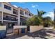 View of a stylish townhome features private balconies, well-maintained landscaping, and convenient trash and recycling area at 1206 Gulf Blvd # C, Indian Rocks Beach, FL 33785