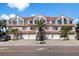 Charming townhome features multiple units, garages, tile roof, palm trees, and inviting curb appeal at 1206 Gulf Blvd # C, Indian Rocks Beach, FL 33785
