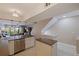 Open-concept kitchen featuring stainless appliances, breakfast bar, and access to the living area and staircase at 1206 Gulf Blvd # C, Indian Rocks Beach, FL 33785