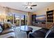 Cozy living room featuring a leather sofa, ceiling fan, and balcony access with a view at 1206 Gulf Blvd # C, Indian Rocks Beach, FL 33785