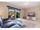Bright living room with a large sliding glass door leading to a patio, streaming TV, and leather couch at 1206 Gulf Blvd # C, Indian Rocks Beach, FL 33785
