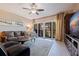 Comfortable living room featuring a ceiling fan, a leather sofa, and a sliding glass door to the balcony at 1206 Gulf Blvd # C, Indian Rocks Beach, FL 33785