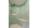 Modern shower with green hexagonal tile, a bench, and a gold shower head at 1206 Gulf Blvd # C, Indian Rocks Beach, FL 33785