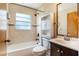 Bathroom with a tub shower, tiled walls, dark vanity, and a built-in cabinet at 12129 Meadow Ln, San Antonio, FL 33576