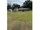 Large grassy backyard with sheds and mature trees, offering potential for expansion at 125 S Wiggins Rd, Plant City, FL 33566