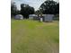 Large grassy backyard with sheds and mature trees offers plenty of space at 125 S Wiggins Rd, Plant City, FL 33566