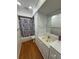 Bathroom featuring a vanity with marble countertop and tiled shower with colorful shower curtain at 125 S Wiggins Rd, Plant City, FL 33566