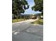 Long driveway leading to a single-story home with a metal roof and manicured front landscaping at 125 S Wiggins Rd, Plant City, FL 33566