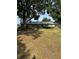 Charming single-story home with a metal roof, stone siding, and a spacious front yard shaded by mature trees at 125 S Wiggins Rd, Plant City, FL 33566
