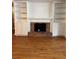 Living room featuring a fireplace with a brick surround and built-in bookshelves at 125 S Wiggins Rd, Plant City, FL 33566