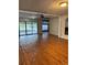 Open living room featuring beautiful wood flooring and sliding glass doors to the outdoor pool at 125 S Wiggins Rd, Plant City, FL 33566
