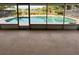 Enclosed pool area with in-ground pool and view of fenced backyard with tropical landscaping at 125 S Wiggins Rd, Plant City, FL 33566