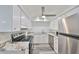 Galley kitchen featuring stainless steel appliances, modern white cabinets and granite countertops at 1301 Gulf Blvd # 107, Clearwater Beach, FL 33767