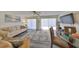 Bright living room with neutral decor, plush rug, ceiling fan, and water views at 1301 Gulf Blvd # 107, Clearwater Beach, FL 33767
