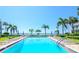 Large outdoor pool with lounge chairs and umbrellas surrounded by lush greenery and waterfront views at 1301 Gulf Blvd # 107, Clearwater Beach, FL 33767