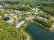 Aerial view of the condo complex surrounded by mature trees and a picturesque lake at 1400 Pine Glen Ln # B2, Tarpon Springs, FL 34688