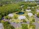 Community aerial view shows lush landscaping, a pond, trees, and ample parking at 1400 Pine Glen Ln # B2, Tarpon Springs, FL 34688
