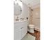 Well-lit bathroom featuring a vanity, round mirror, toilet and shower with tiled walls at 1400 Pine Glen Ln # B2, Tarpon Springs, FL 34688