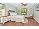 Bedroom with aqua walls, a queen bed, and two windows with tree views and white nightstands at 1400 Pine Glen Ln # B2, Tarpon Springs, FL 34688