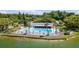 Aerial view of the community pool area with sun loungers, umbrellas, and lake views at 1400 Pine Glen Ln # B2, Tarpon Springs, FL 34688