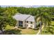 The exterior of a two-story condo building with a screened balcony, surrounded by mature trees and landscaping at 1400 Pine Glen Ln # B2, Tarpon Springs, FL 34688