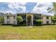 Low-angle view of the neutral-toned exterior of this two-story condominium building with lush landscaping and a central staircase at 1400 Pine Glen Ln # B2, Tarpon Springs, FL 34688