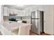 Bright kitchen with white cabinets, stainless steel appliances and a white countertop island with seating at 1400 Pine Glen Ln # B2, Tarpon Springs, FL 34688