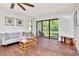 Sunlit living room with hardwood floors, casual decor, and a sliding glass door that opens onto a screened balcony at 1400 Pine Glen Ln # B2, Tarpon Springs, FL 34688