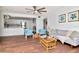 Bright open living room with stylish decor, hardwood flooring, and open access to an adjacent, modern, white kitchen at 1400 Pine Glen Ln # B2, Tarpon Springs, FL 34688