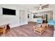 Well-lit open-concept living space showcasing wood-look floors and stylish furnishings flowing into a modern, white kitchen at 1400 Pine Glen Ln # B2, Tarpon Springs, FL 34688