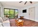 Living room featuring wood-look flooring, casual furnishings, and a sliding glass door opening onto a screened patio at 1400 Pine Glen Ln # B2, Tarpon Springs, FL 34688