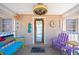 Inviting front porch with colorful furniture and coastal decor, creating a relaxing outdoor space at 1507 Legion Ln, Indian Rocks Beach, FL 33785