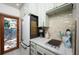 Galley kitchen features white marble counters, light green cabinets, and stainless steel refrigerator at 1507 Legion Ln, Indian Rocks Beach, FL 33785