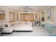 Bright living room with a white sectional sofa, tile flooring, and stylish coastal decor at 1507 Legion Ln, Indian Rocks Beach, FL 33785