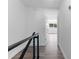 Hallway with modern black railing, and doorway to bedroom featuring window and ceiling fan at 1700 Azalea Ct # B, Oldsmar, FL 34677