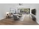 Bright living room featuring hardwood floors, modern ceiling fan and sliding glass doors to the outdoor space at 1700 Azalea Ct # B, Oldsmar, FL 34677