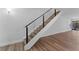Modern staircase with wood treads and a sleek black metal railing, complemented by wood-look flooring at 1700 Azalea Ct # B, Oldsmar, FL 34677