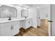 A stylish bathroom featuring double vanities, sleek black fixtures, and modern white cabinets at 18238 Clear Lake Dr, Lutz, FL 33548