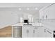 Open-concept kitchen with white cabinets, quartz countertops, stainless steel appliances, and wood-look vinyl plank flooring at 18238 Clear Lake Dr, Lutz, FL 33548