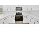 Modern kitchen features white cabinets, quartz countertops, stainless steel appliances, and marble backsplash at 18238 Clear Lake Dr, Lutz, FL 33548
