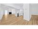 Open-concept living space with sleek wood-look floors, modern kitchen with stainless steel appliances, and a cozy fireplace at 18238 Clear Lake Dr, Lutz, FL 33548