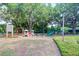 Community playground featuring a slide, swings, climbing structure, and picnic tables under mature shade trees at 18238 Clear Lake Dr, Lutz, FL 33548