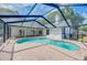 A kidney shaped private pool is surrounded by brick pavers inside of a screened enclosure at 18238 Clear Lake Dr, Lutz, FL 33548