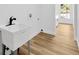 Laundry room with laminate flooring, utility sink, and backyard window at 18238 Clear Lake Dr, Lutz, FL 33548