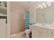 Bright bathroom featuring a walk-in shower, white vanity, and beachy decor at 19417 Gulf Blvd # E217, Indian Shores, FL 33785