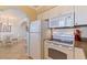 This kitchen features tile floor, white appliances, and a view of the dining area at 19417 Gulf Blvd # E217, Indian Shores, FL 33785