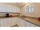 Efficient kitchen with white cabinetry, granite countertops and stainless sink at 19417 Gulf Blvd # E217, Indian Shores, FL 33785