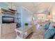 A cozy living room flows into the dining and kitchen areas. The space features a sofa, TV and coastal decor at 19417 Gulf Blvd # E217, Indian Shores, FL 33785